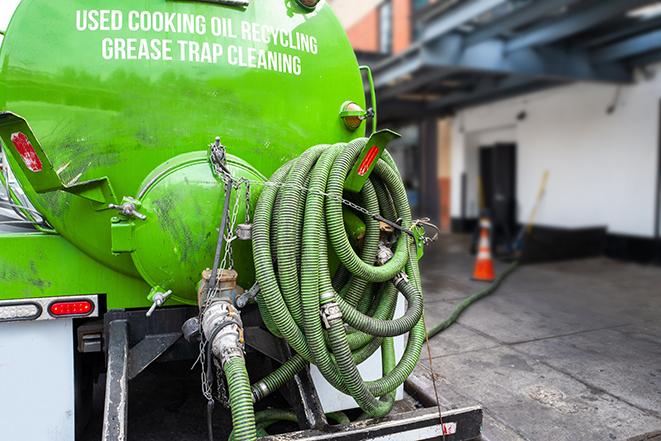 a grease trap being pumped by a sanitation technician in Saratoga, CA